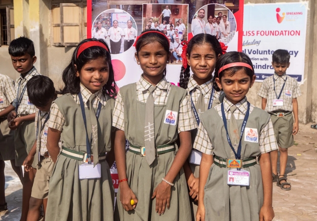 Schoolchildren in uniform smiling together at a community event organised by Spreading Bliss Foundation, highlighting education, child development, and volunteer engagement.