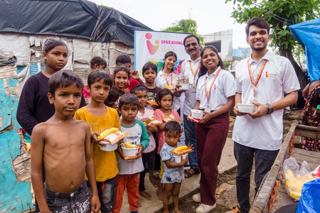 Spreading Bliss Foundation volunteers distributing food to underprivileged children during their weekly food drive in an underserved community in India. 




