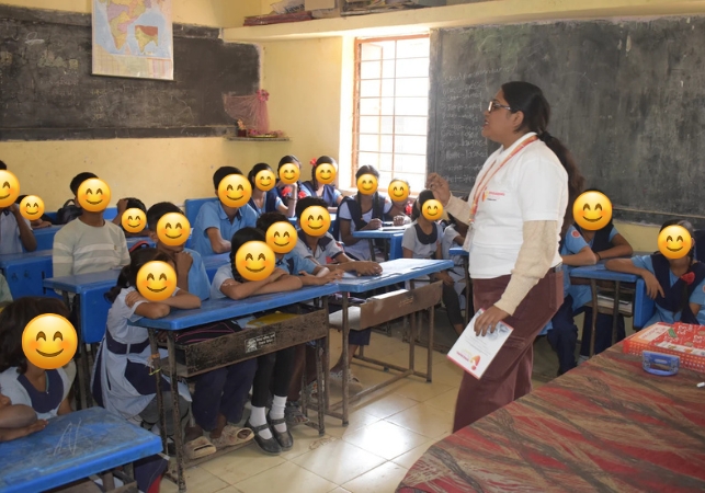 A Spreading Bliss Foundation volunteer addressing underprivileged children in a classroom, reflecting SBF's commitment to ensuring every child has access to education regardless of their financial circumstances. 

 


