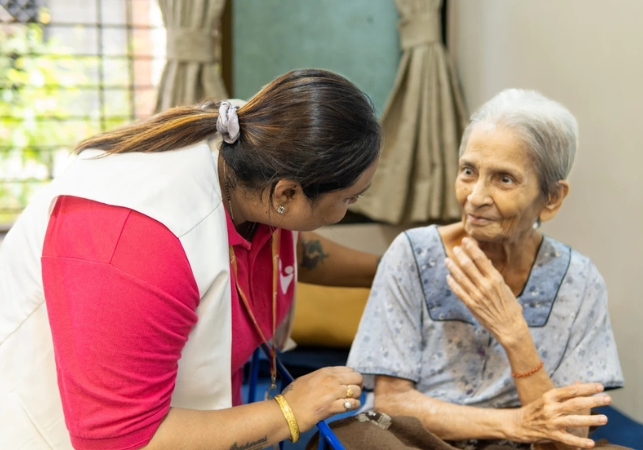 Spreading Bliss Foundation volunteer warmly interacting with an elderly woman during a home visit, illustrating compassionate care, emotional support, and community healthcare services.