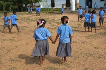 Two small girls walking in the school ground and holding hands
 




